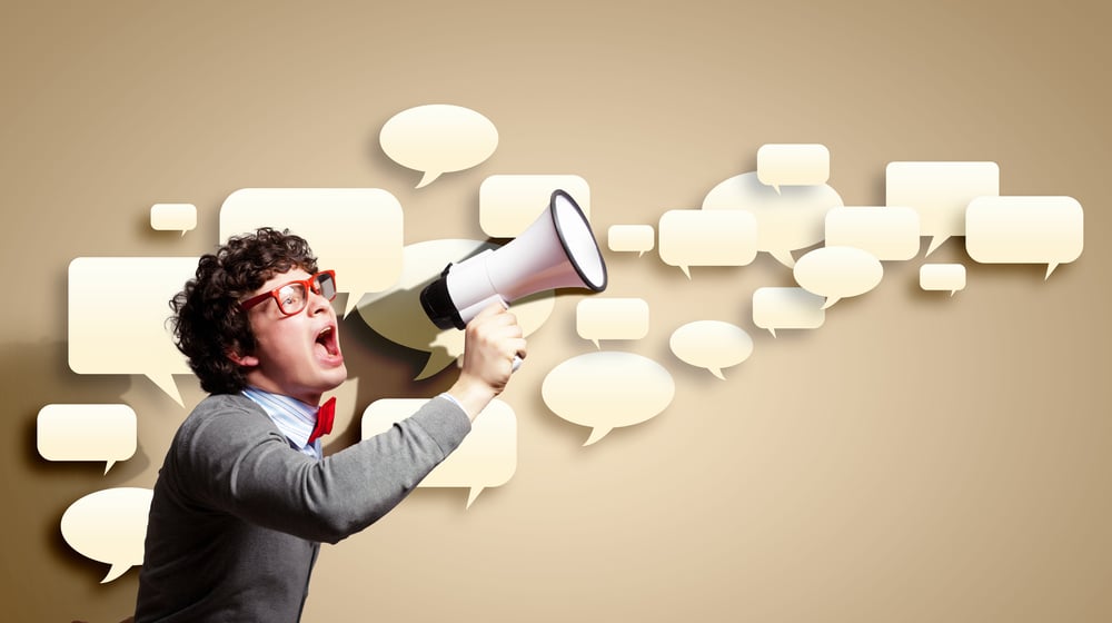 Portrait of young man shouting loudly using megaphone